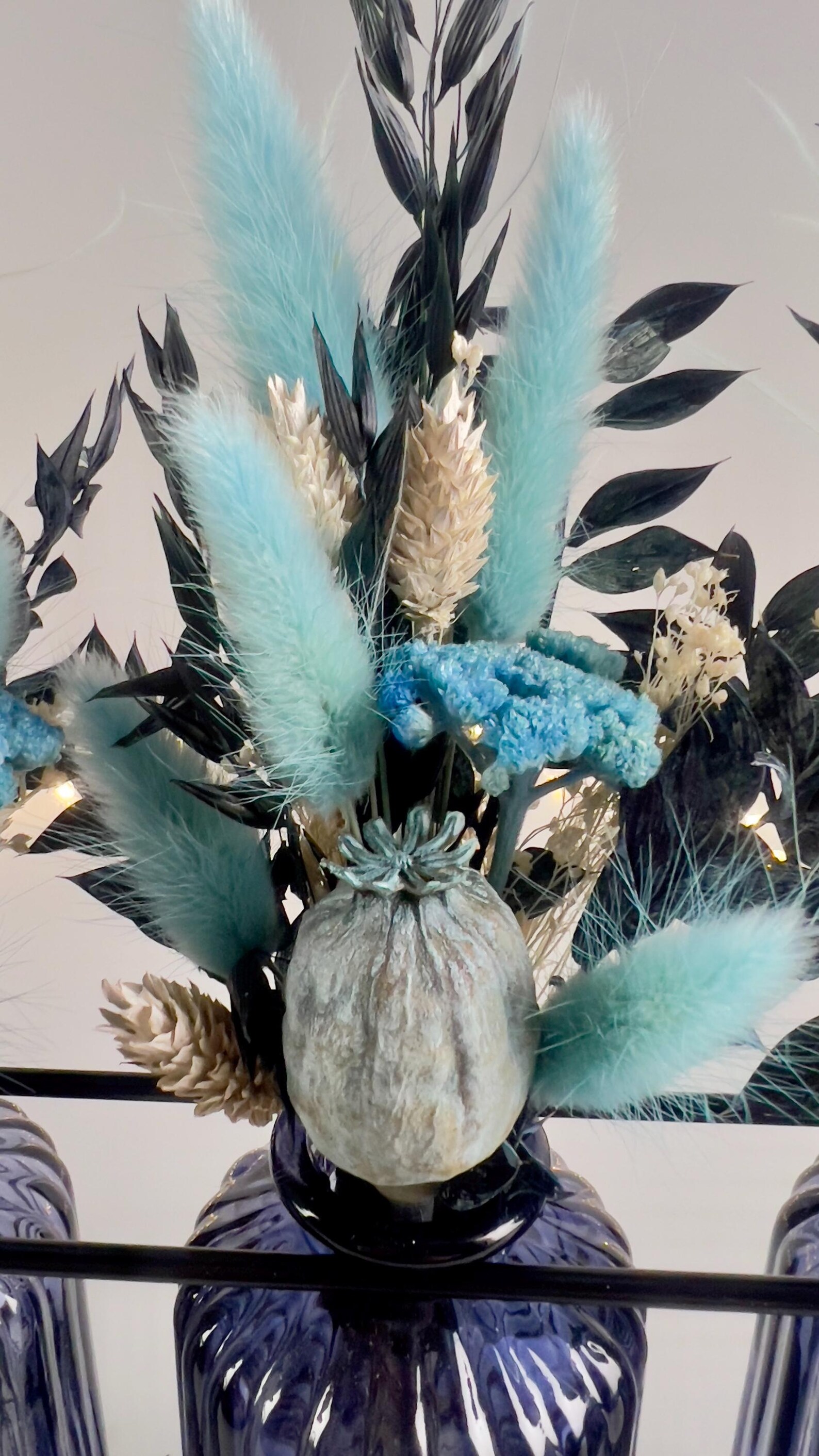Trockenblumensträuße in blauen Glasvasen – Vorschaubild