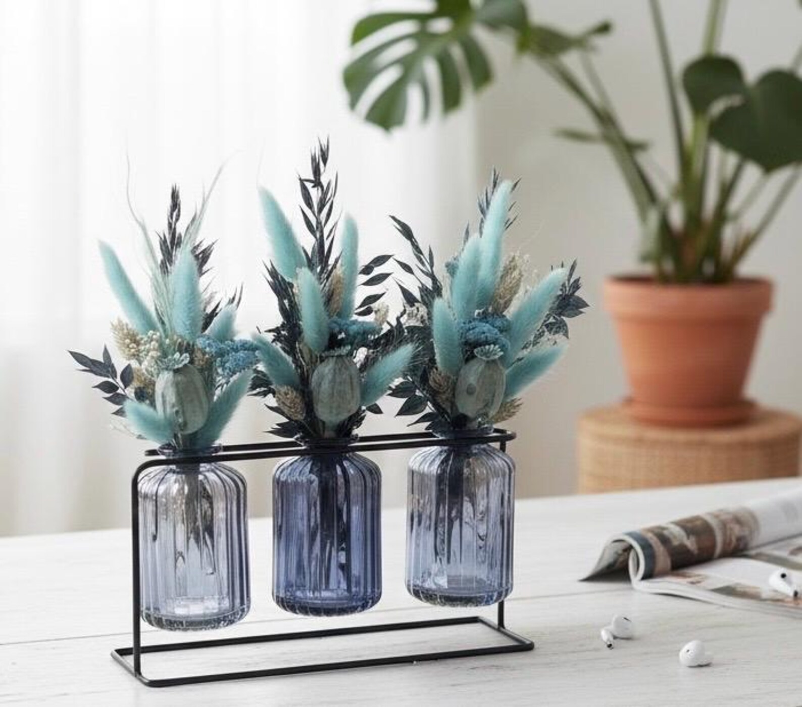 Trockenblumensträuße in blauen Glasvasen